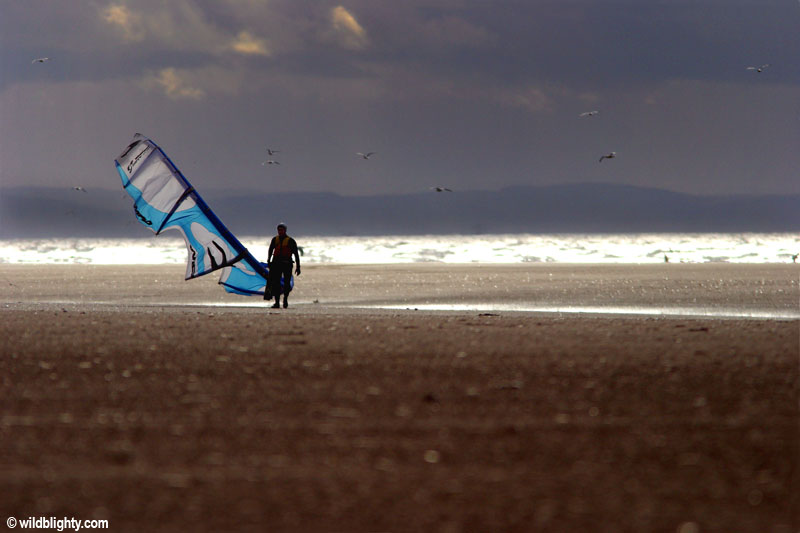 Kitesurfer walking up the beach at Ainsdale at popular Kitesurfing location.