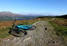 Mountain bike on bridleway with forest and mountains beyond.